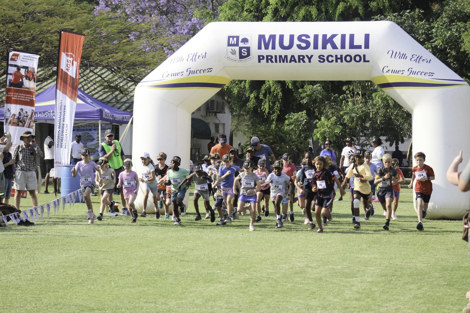 Young runners setting off under the Musikili start arch at the triathlon